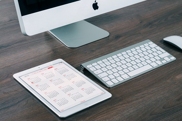 calendar on tablet beside mac pc and keyboard